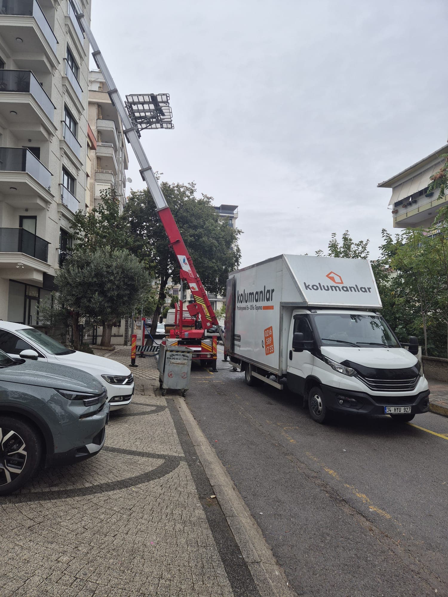 Apartman önünde kurulmuş dış cephe taşıma asansörü ve nakliye aracı