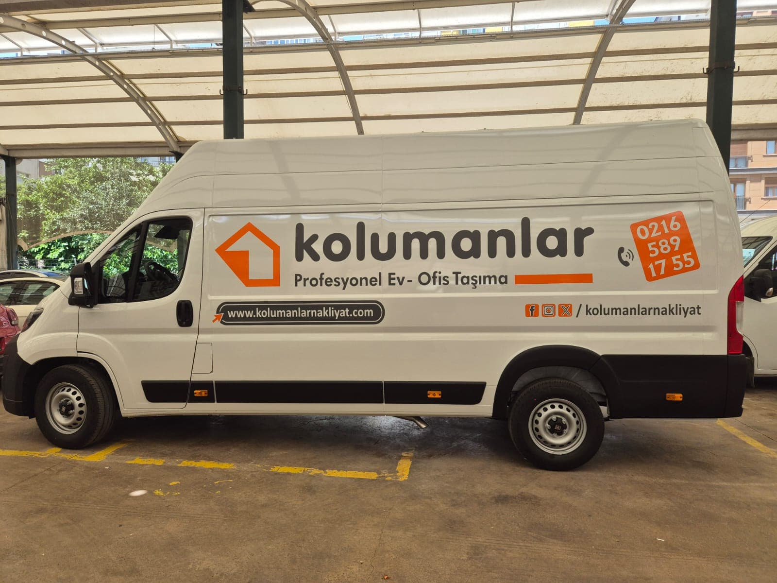 Üzeri logolu beyaz nakliye aracı